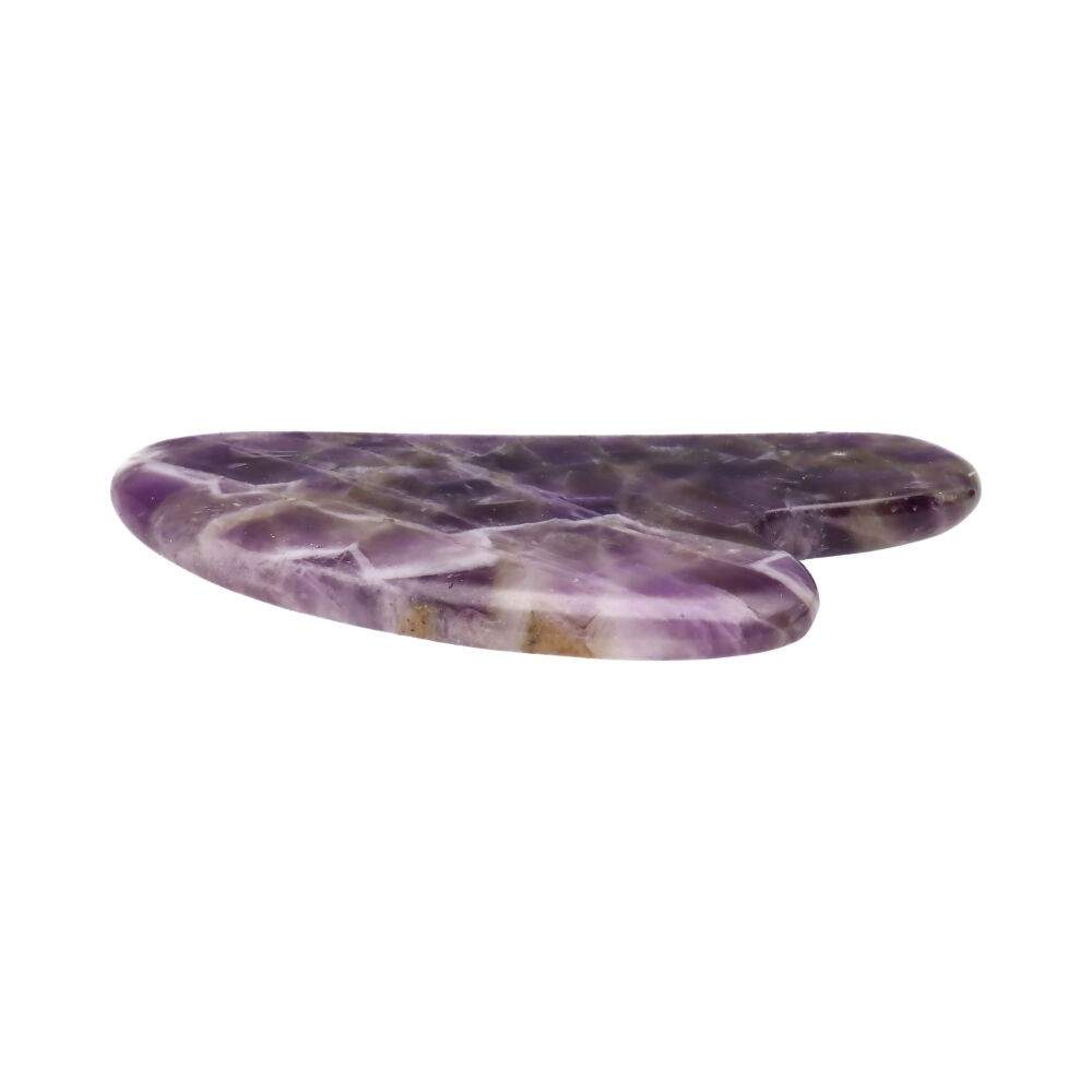 Lila Amethyst Gua Sha Stein auf weißem Hintergrund. Natürliches Massage-Tool zur Gesichtspflege, Entspannung und Förderung der Durchblutung.