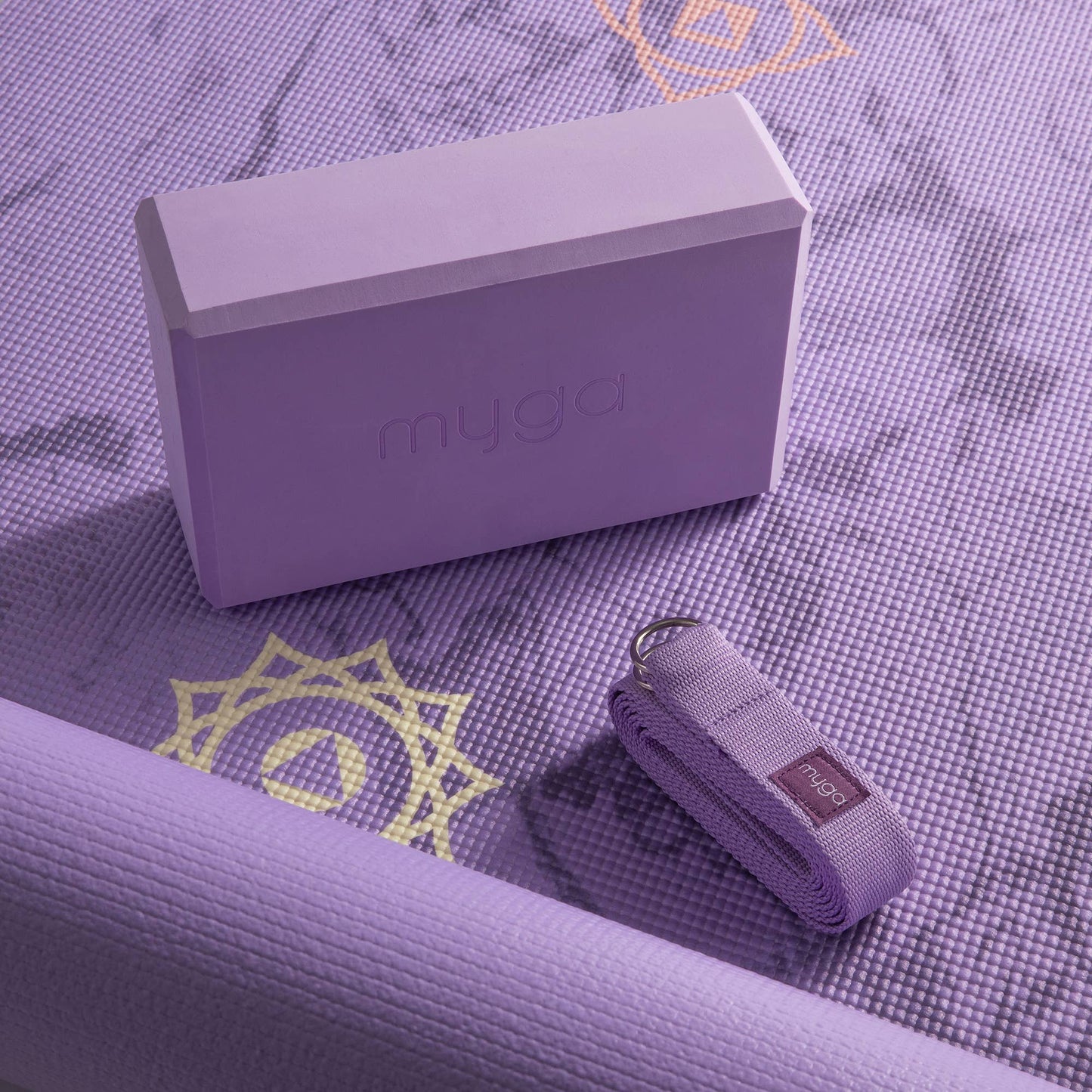 Lila Yoga-Set von Myga mit Yogamatte, Yogablock und Gurt – Nahaufnahme mit Mandala-Motiv auf der Matte.