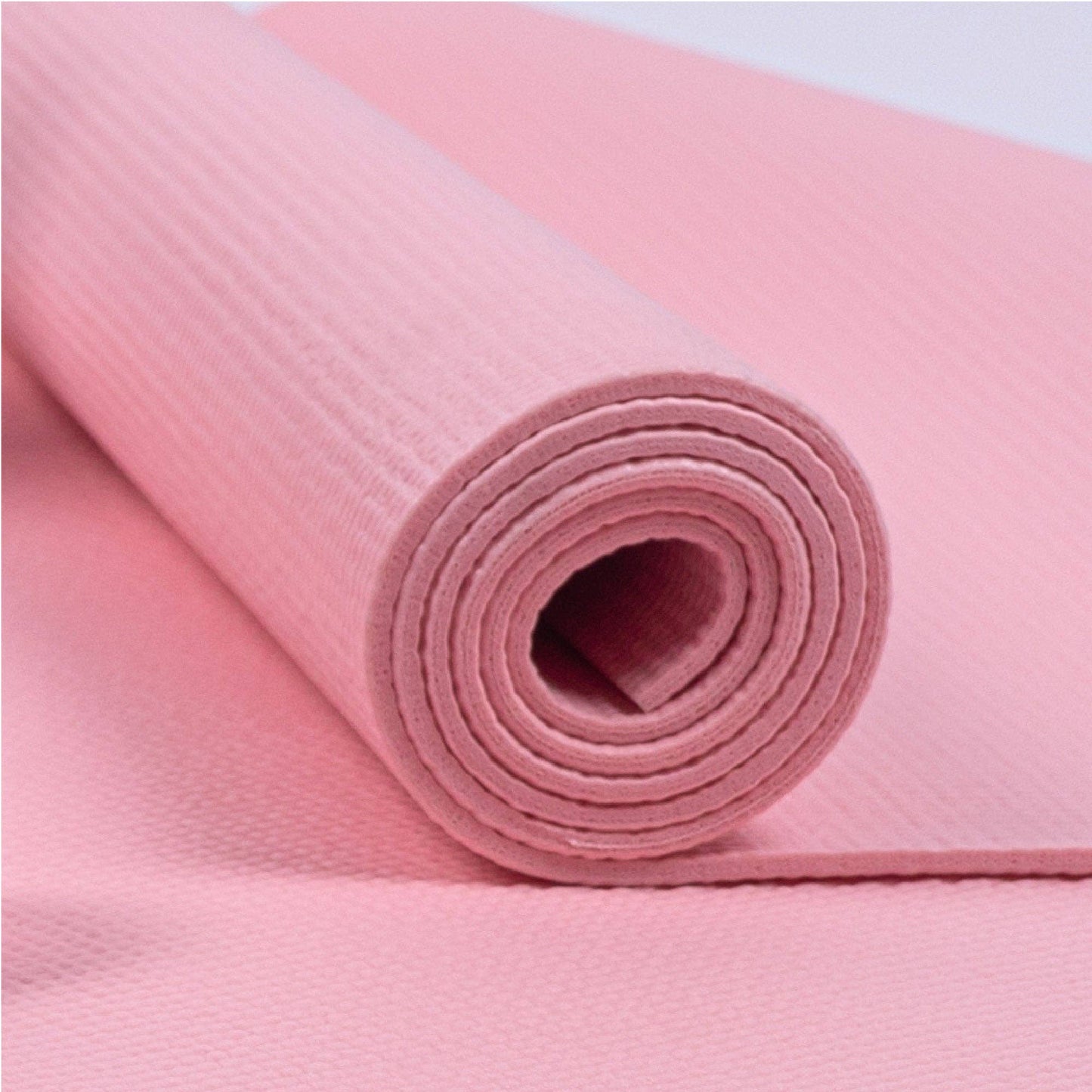 Gerollte rosa Yogamatte aus dem Myga Yoga-Set. Strukturierte Oberfläche für rutschfesten Halt.