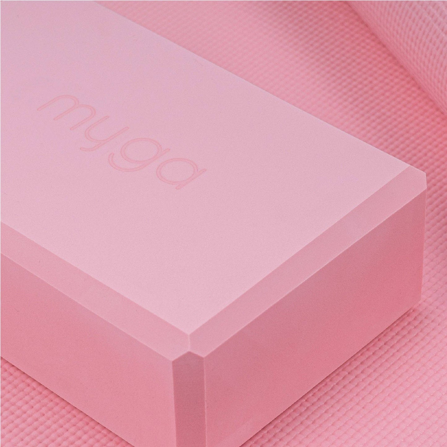 Rosa Yoga-Block von Myga auf passender Yogamatte. Leichtes Zubehör zur Unterstützung von Yoga-Positionen.