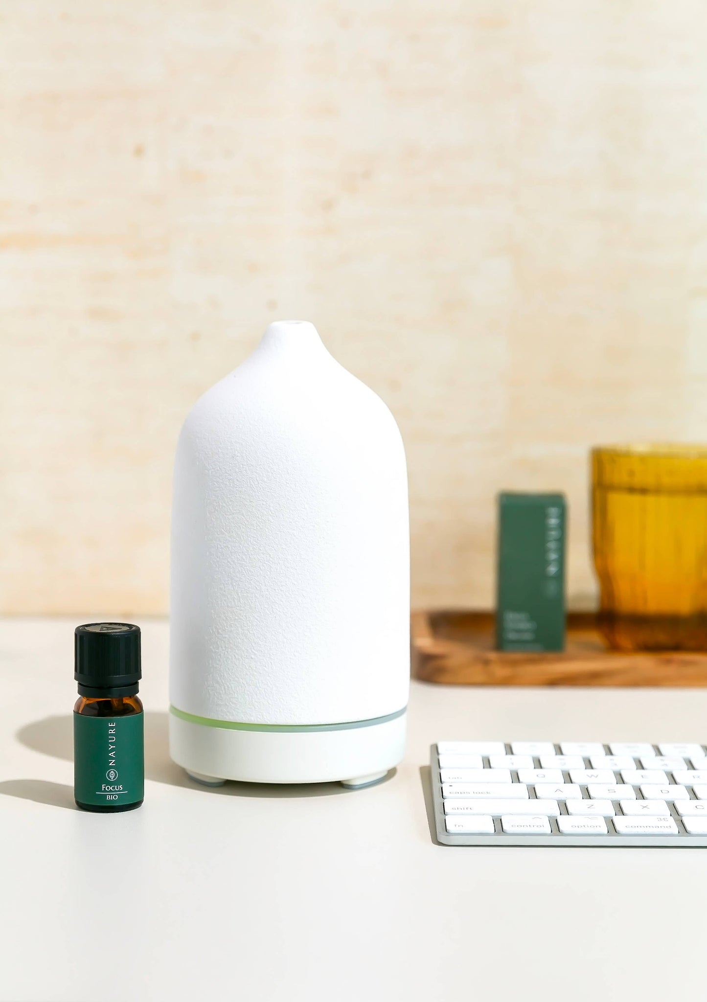 Ätherisches Bio-Öl NAYURE Focus Synergy neben einem weißen Diffuser auf einem Tisch. Natürliches Öl zur Förderung von Konzentration und geistiger Klarheit.