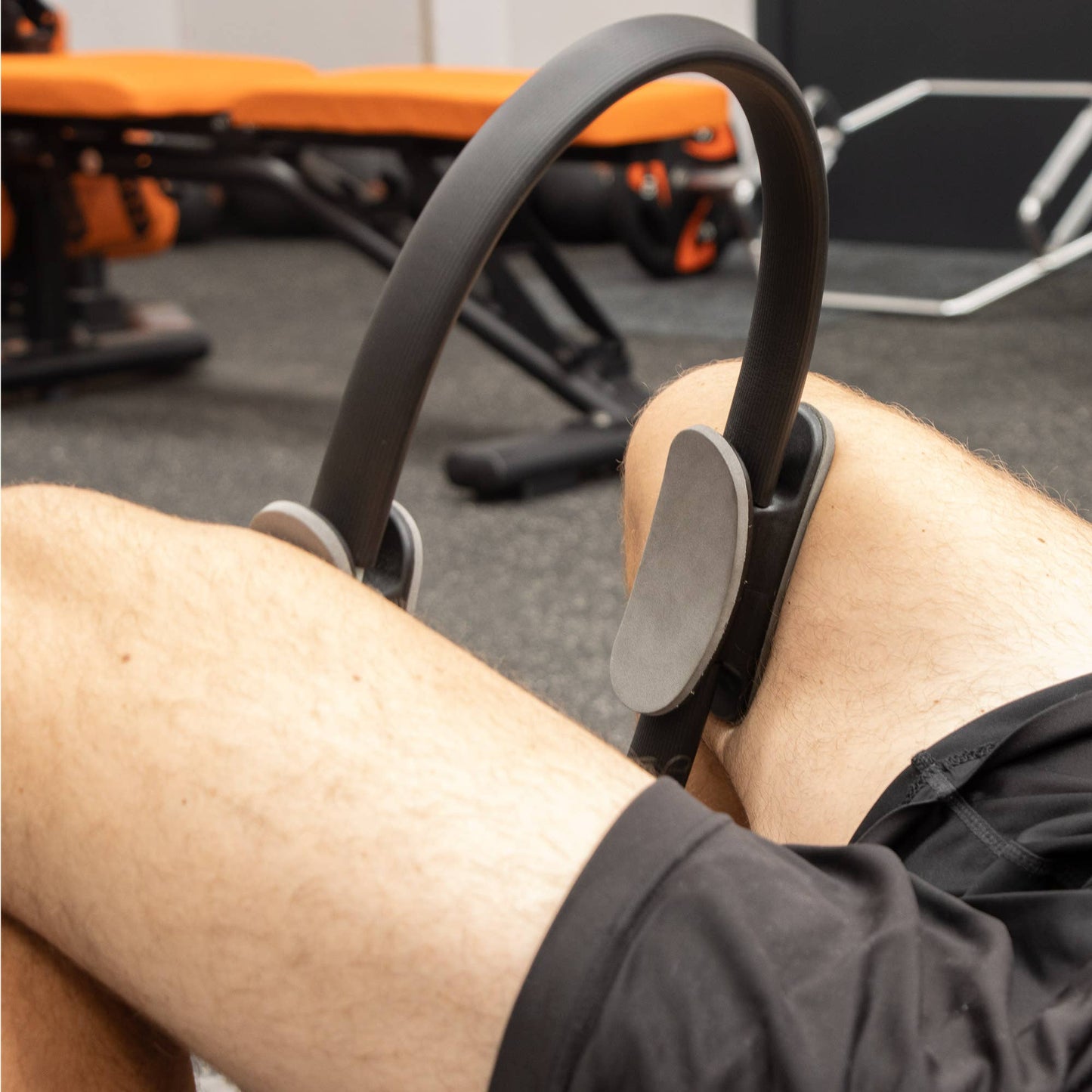 Anwendung des Pilatesrings beim Beintraining im Fitnessstudio.