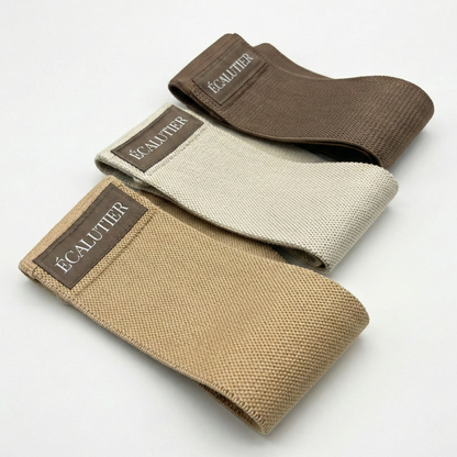 Drei Pilates Widerstandsbänder aus Stoff in Beige und Braun für das Training