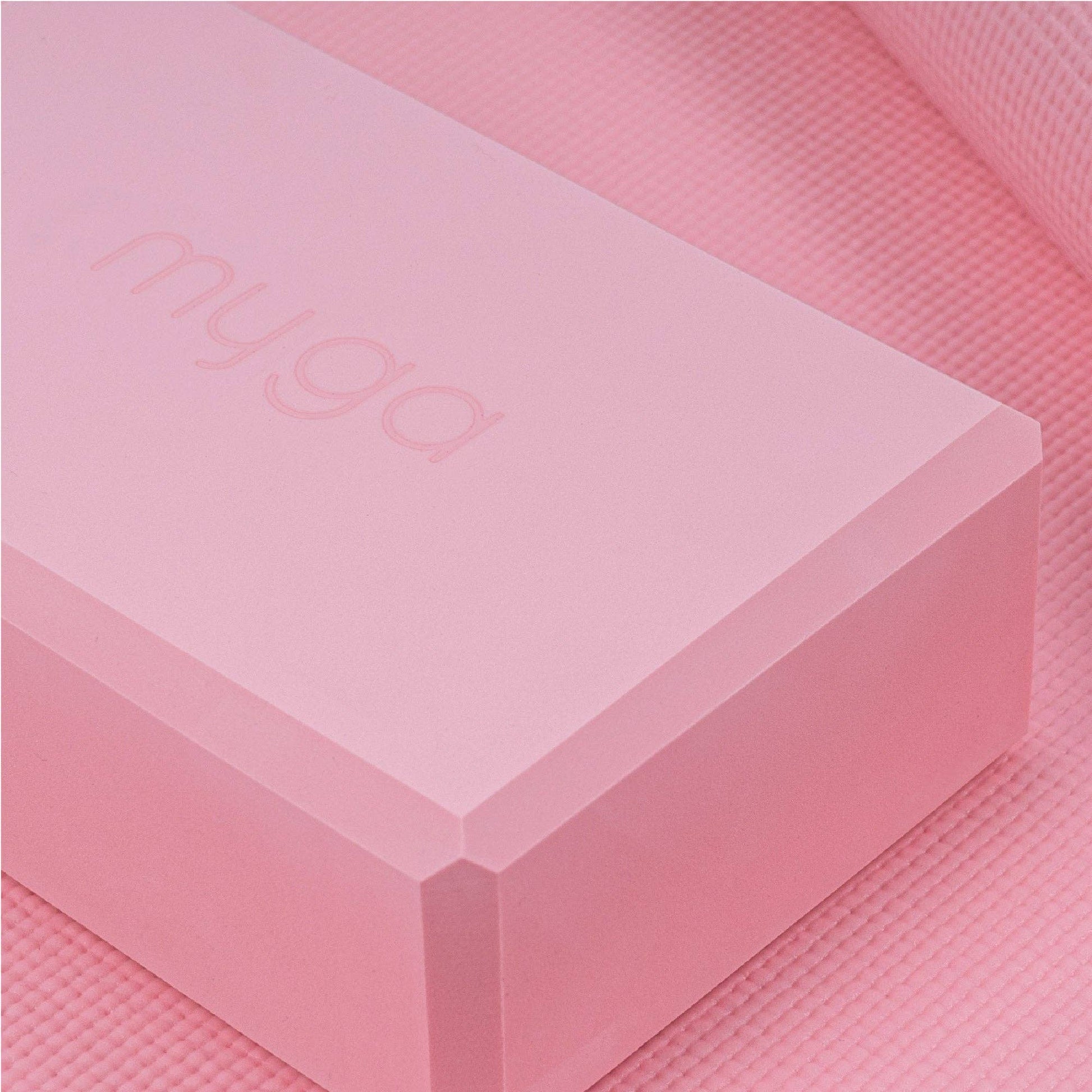 Rosa Yoga-Block von Myga auf passender Yogamatte. Leichtes Zubehör zur Unterstützung von Yoga-Positionen.