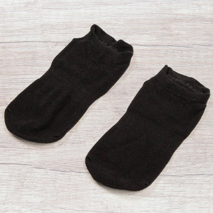 myga Yoga Socken Schwarz auf hellem Untergrund liegend.